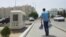 Turkmenistan -- Boy carrying the pack of water. Police box. Ashgabat. June 9, 2014