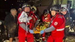 Спасителен екип изнася ранен от жилищна сграда в Харков, 23 нормври 2025 г.