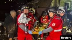 Медичні працівники несуть тіло, виявлене на місці російського удару, Харків, 23 листопада 2025 року