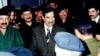 Saddam Hussein surrounded by army officers in 2003