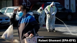 Romanian workers disinfect the parking lot of a supermarket in Bucharest on April 6.