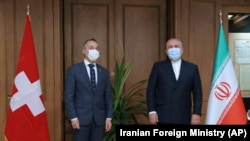 IRAN -- Iranian Foreign Minister Mohammad Javad Zarif, right, and his Swiss counterpart Ignazio Cassis wearing protective face masks to help prevent spread of the coronavirus pose for media prior to their meeting in Tehran, September 7, 2020