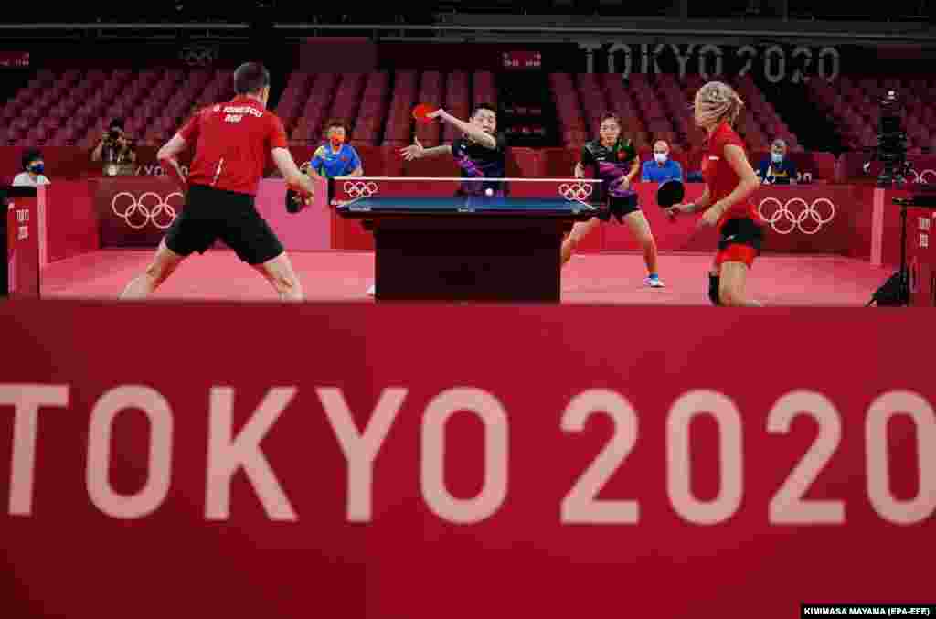Сюй Синь (в центре слева) и Лю Шивэнь (в центре справа) из Китая в бою против Овидиу Ионеску (слева) и Бернадетт Соц (справа) из Румынии во время четвертьфинала в смешанном настольном теннисе Олимпийских игр 2020 года в Токио, Япония, 25 июля 2021 года