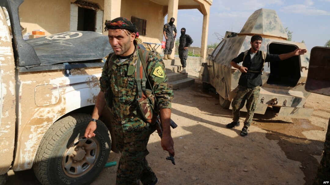 U.S.-backed Kurdish and Arab fighters advance into the Islamic State bastion of Manbij in northern Syria on June 23.