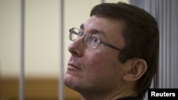 Former Interior Minister Yuriy Lutsenko looks on from the defendant's cage in court in Kyiv in July.