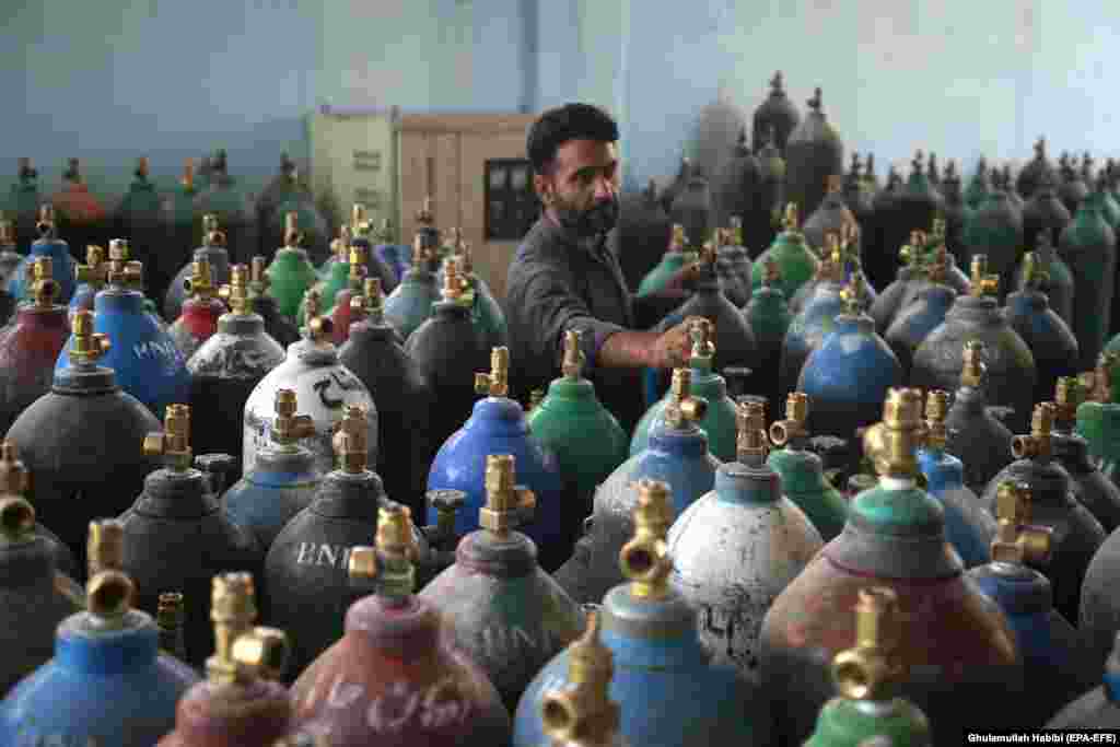 An Afghan man refills oxygen cylinders at a factory as demand for oxygen rises due to increasing COVID-19 infections, in Jalalabad.