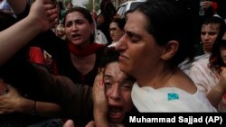 A Pakistani transgender comforts her colleague who mourns the death of her friend, during a protest in Peshawar on August 20