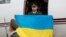 Ukrainian National Guard serviceman Vitaliy Markiv holds a Ukrainian national flag as he arrives at an airport in Kyiv on November 4.
