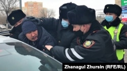 Police detain people protesting during parliamentary elections in Aqtobe on January 10.