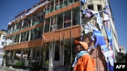 An Afghan municipality worker looks on in front of a damage wedding hall building near the site of a car bomb attack in western Kabul on July 24.