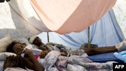 Wouded people lie in a makeshift shelter in the parking lot of the general hospital in Port-au-Prince on January 14.