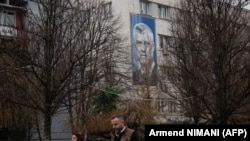 Fotografia e Thaçit afër selisë së Partisë Demokratike të Kosovës, parti e themeluar nga vetë ai.