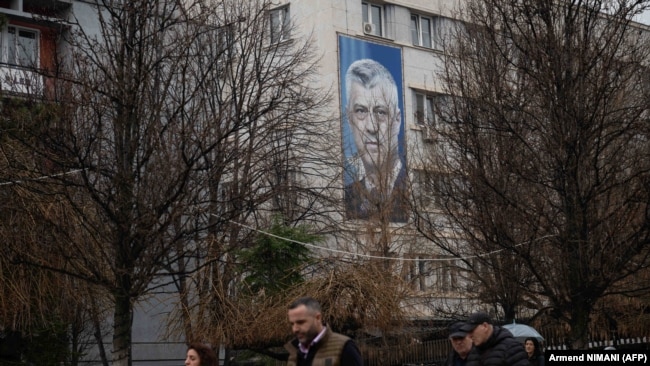 Fotografia e Thaçit afër selisë së Partisë Demokratike të Kosovës, parti e themeluar nga vetë ai.