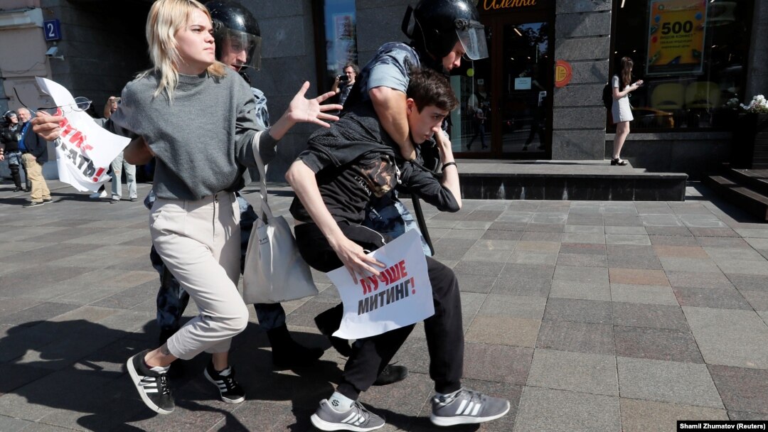Полицейские ведут задержанных участников манифестации в Москве, 27 июля 2019