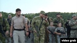 A screengrab from a video posted on Ramzan Kadyrov's VKontakte account of snap defensive drills and inspections that the Chechen strongman ordered, apparently with a view to illustrating the Caucasus republic's defensive readiness.It also shows Kadyrov (center) with a group of armed children dressed in fatigues. 