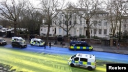 The campaign group Led By Donkeys halted traffic before spreading more than 300 liters of paint across the road using wheelbarrows and brushes to make the 500-square-meter (5,382-square-foot) flag outside the Russian Embassy in London on February 23.