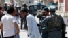 Afghan policemen try to comfort a man whose relatives were stuck at the site of a suicide attack followed by a clash between Afghan forces and insurgents after an attack on a Shi'ite Muslim mosque in Kabul on August 25.