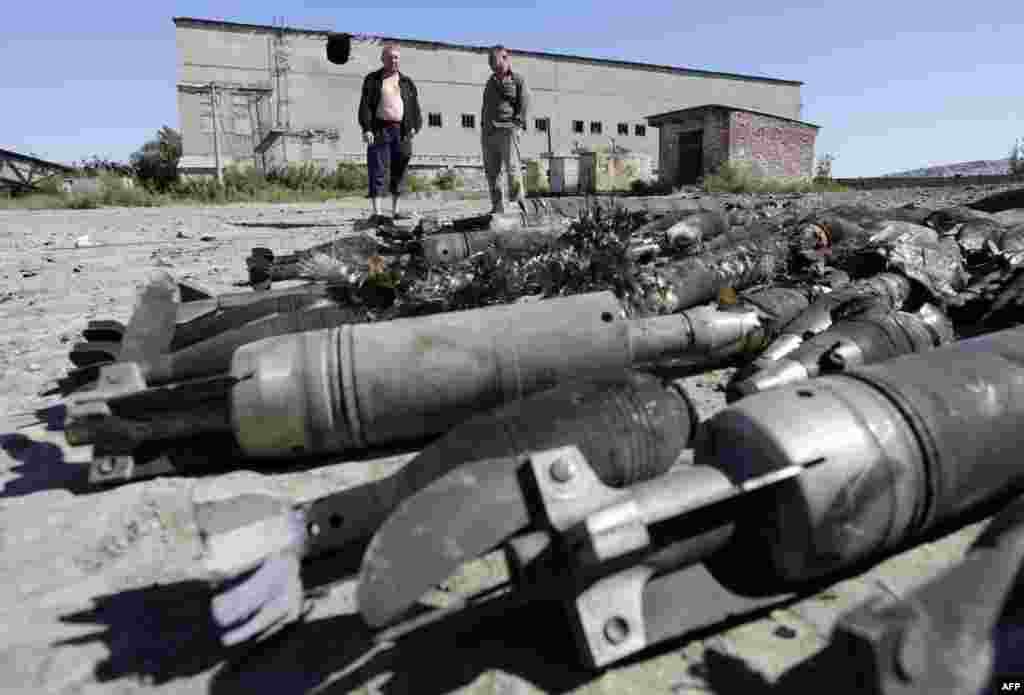 Residents of Kurdyumivka look at an ammunition depot of the Ukrainian armed forces that was destroyed by pro-Russian separatists with Russian Krasnopol guided shells. Two Ukrainian soldiers were killed and 14 more injured over 24 hours in clashes between government forces and pro-Russian rebels in eastern Ukraine, a security official in Kyiv said on August 2. (AFP/Anatolii)