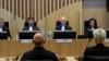 NETHERLANDS -- Presiding judge Hendrik Steenhuis, rear second from right, waits for Ria van der Steen, who lost her father and stepmother in the MH17 crash, right, to give testimony in court in the trial of four men charged with murder over the downing of