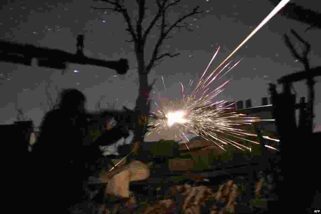 Ukrainian servicemen fire machine guns during fighting with pro-Russia separatists in Avdiyivka. (AFP/Anatolii Stepanov)