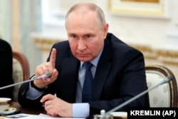 Russian President Vladimir Putin gestures as he speaks during a meeting with Russian war correspondents covering the conflict in Ukraine, at the Kremlin in Moscow on June 13.