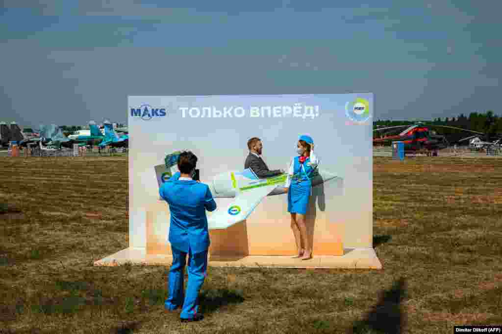 A man and a flight attendant pose for a photograph during the opening day of the MAKS-2021 International Aviation and Space Salon at Zhukovsky outside Moscow.