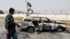 An Afghan police officer inspects a vehicle from which insurgents fired rockets into Kabul on August 18.