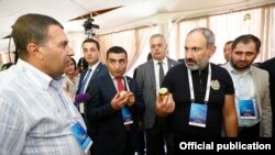 Armenia -- Prime Minister Nikol Pashinian and Kotayk Governor Romanos Petrosian (second from left) visit a trade expo held during an investment forum in Tsaghkadzor, August 17, 2019.