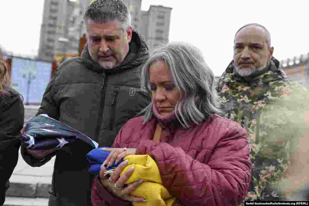 Леслі та Джон Гертвеки, батьки 21-річного Ітана Хертвека, тримають в руках прапори США й України, якими була вкрита домовина з тілом їхнього сина &nbsp;