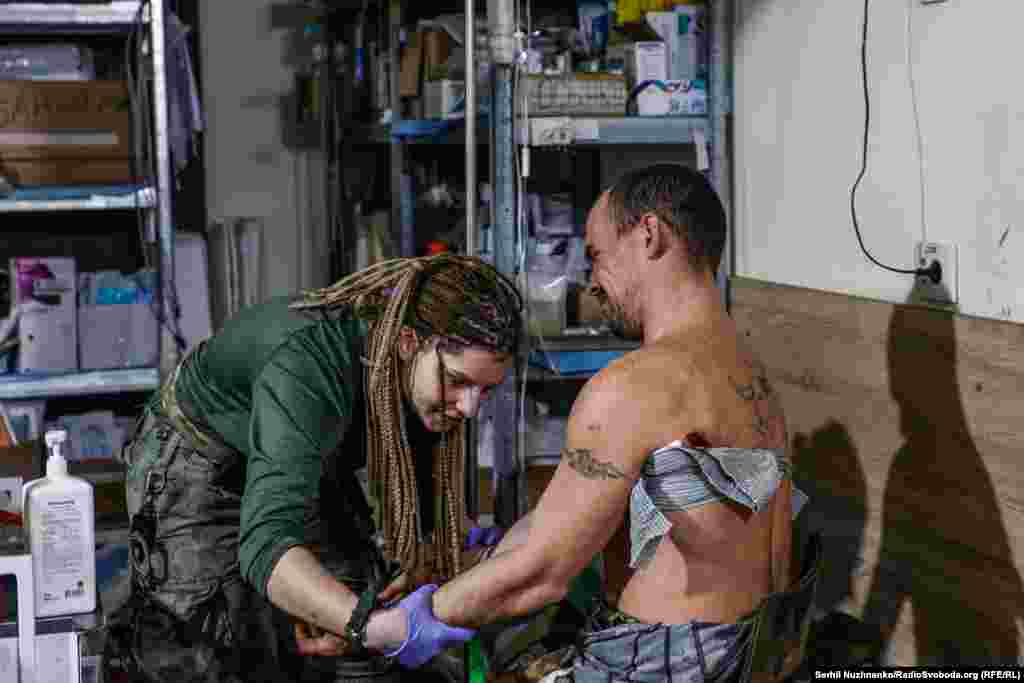 Військова медикиня, волонтерка, 29-річна Яна «Яра» Рихліцька з Вінниці надає допомогу пораненому в стабпункті в Бахмуті, листопад 2022 року.У березні 2023-го вона загинула внаслідок російського обстрілу