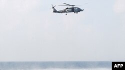 Indian Ocean -- Search and seizure team members (L) from the guided-missile cruiser USS Vella Gulf close in to apprehend suspected pirates in the Gulf of Aden, 12Feb2009