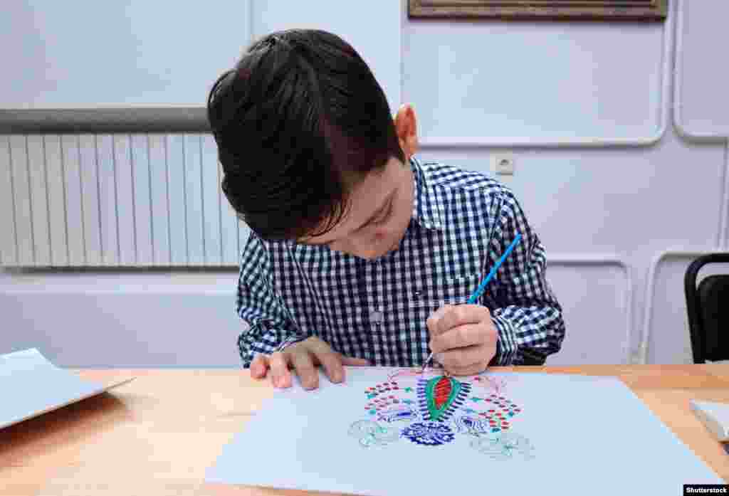 A schoolboy in Kyiv drawing an ornek pattern. The artistic tradition nearly died out under Soviet rule.
