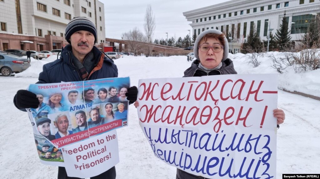 Гражданские активисты Аскар Сембай и Асия Бакаева проводят пикет перед зданием Верховного суда в поддержку политзаключенных. Нур-Султан, 28 декабря 2021 года