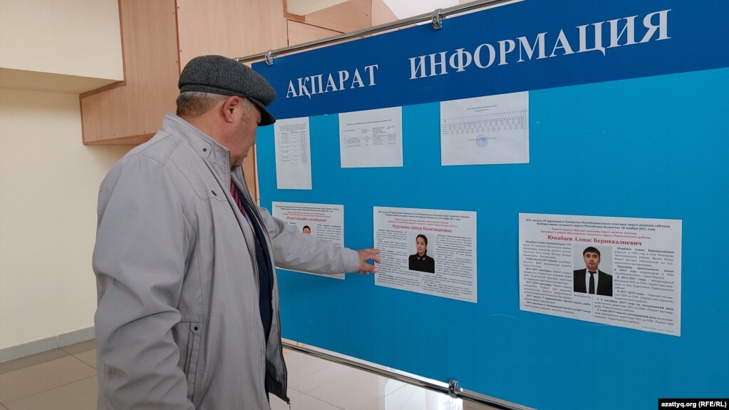 Мужчина у стенда с информацией о кандидатах на должность сельского акима. Западно-Казахстанская область, 25 ноября 2021 года