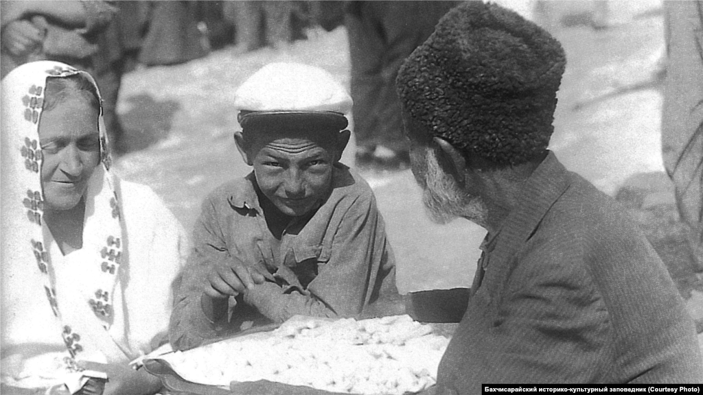 Soqaq tuccarı. Bağçasaray, 1920 seneleri. Çoqusı esnafçı yapqan malını özü sata edi, amma Qırım şeerleri bazarsız olmay edi. Gerdanlıq, zıncır, anter, çubuq ve diger şeyler alıp şeer soqaqlarını dolaşqan satıcılar da bar edi