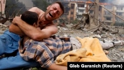 A Georgian man cries as he holds the body of his relative after a bombardment in Gori, 80 kilometers from Tbilisi, in August 2008.