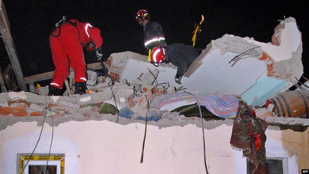 Rescue workers examine the collapsed roof of a building in Kraljevo.