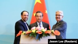 Szalahuddin Rabbani afgán, Ji Veng kínai és Havadzsa Aszif pakisztáni külügyminiszter közös sajtótájékoztatón vesz részt az első kínai–afganisztáni–pakisztáni külügyminiszteri párbeszéd után Pekingben 2017. december 26-án