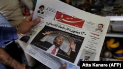 A man takes a glance at a newspaper with a picture of U.S. president Donald Trump on the front page, in the capital Tehran. The headline on photo says "Meeting with Rouhani without preconditions." July 31, 2018