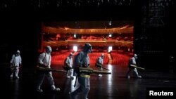 Volunteers from the Blue Sky Rescue team disinfect at the Qintai Grand Theatre in Wuhan, April 2, 2020