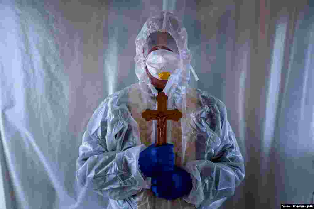 Father Stephan, a Ukrainian Greek Catholic Church priest, wearing a special suit to protect himself against the coronavirus, stands after visiting with COVID-19 patients in the intensive-care unit of an emergency hospital in Lviv in western Ukraine. (AP/Evgeniy Maloletka)
