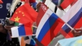 Spectators wave Russian, Chinese, and other flags during a June ceremony in central Moscow marking the 100-day countdown to the upcoming Intervision contest on September 20. 