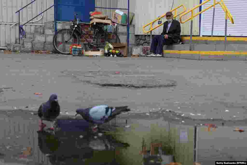 A man sells agricultural produce near a closed supermarket in the city of Pokrovsk, which the Russian Army has been closing in on in recent weeks.&nbsp;