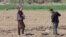 Uzbek farmers work in the field in spring in Karakalpakstan, Uzbekistan, Central Asia - April 2019