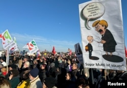  Плакат с подигравка на някогашната канцлерка Ангела Меркел и настоящия водач на ХДС Фридрих Мерц. 