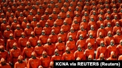 La începutul lunii septembrie, mai multe posturi de televiziune internaționale au difuzat imagini cu parada organizată de liderul nord-coreean, Kim Jong-un, cu ocazia a 73 de ani de la formarea Coreei de Nord. În imagini apar oameni în costume de protecție portocalii.