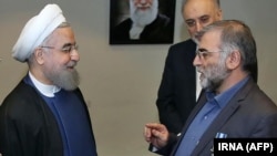 An undated photo issued by IRNA on December 1 shows Iranian President Hassan Rohani (left) awarding nuclear scientist Mohsen Fakhrizadeh a medal in Tehran.