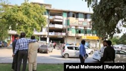 په اسلام اباد کې یوشمېر کسان تر زلزلې وروسته له ودانیو بهر ولاړ دي - پخوانی انځور.