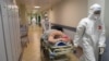 Медицинские работники в средствах индивидуальной защиты переносят пациента, больного коронавирусом, в реанимацию Мариинской больницы. Санкт-Петербург, 7 июля 2021 года