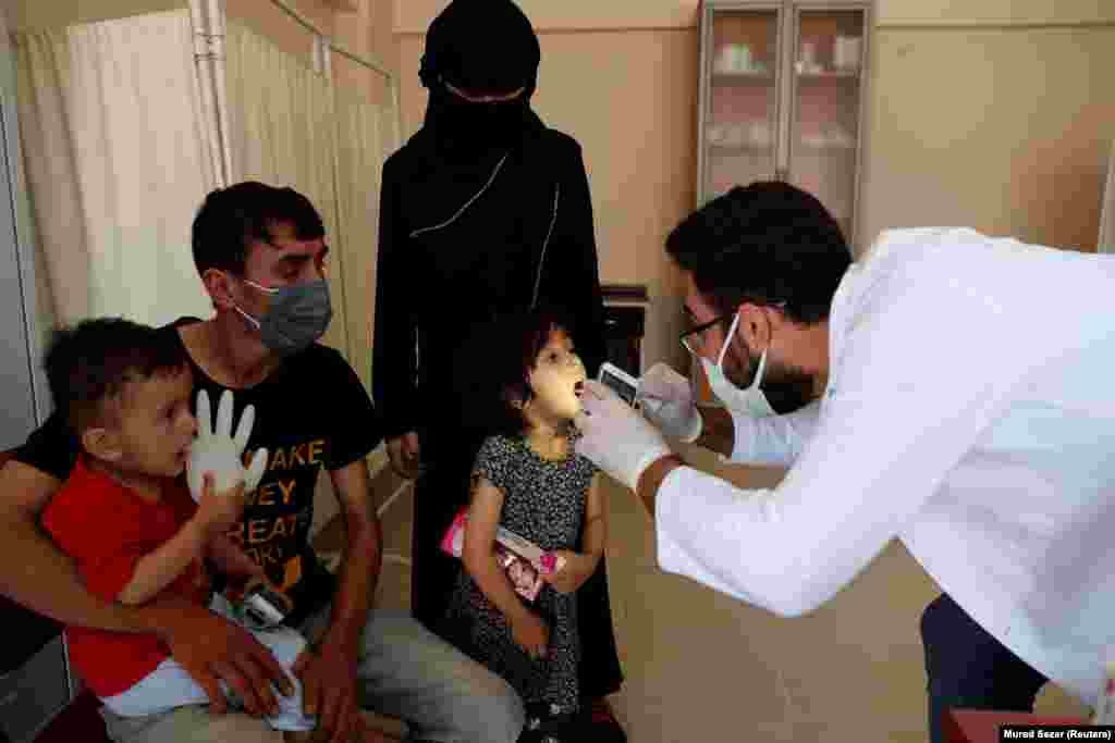 Reyhan Mirzait, a négyéves afgán kislányt vizsgálja az orvos a vani menekültközpontban